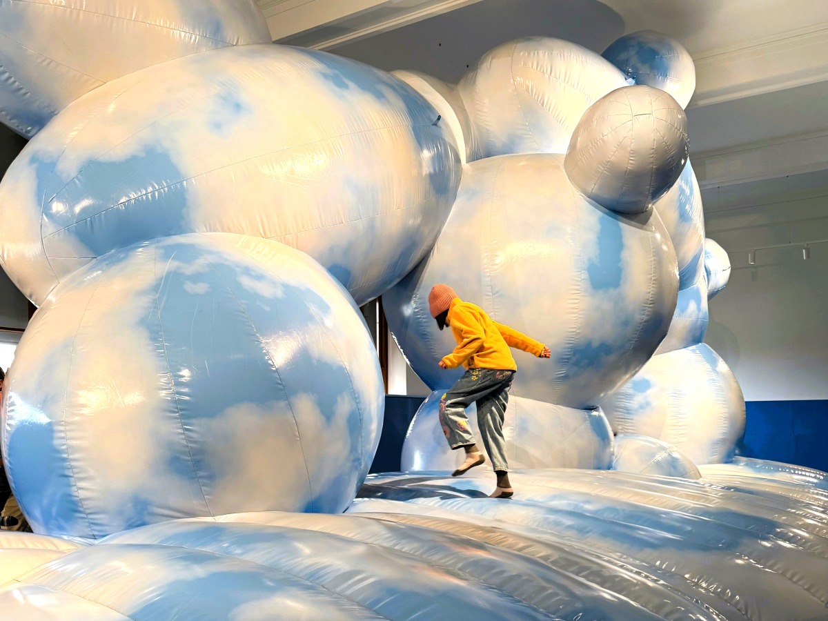 Child jumps on large inflatable art installation in Museum of Prague City