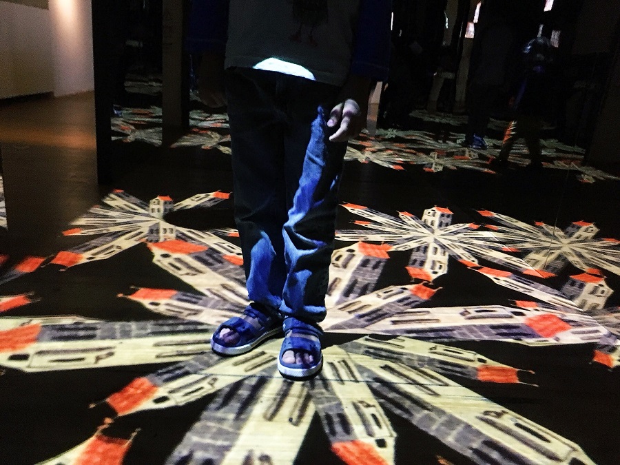 Child standing on a multimedia display about Prague, projected on the floor at the House of the Golden Ring