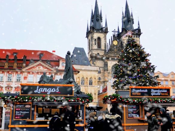 A snowy christmas scene on Old Town Square in Prague. One of the many festive things to do in Prague in December. The Little Adventurer.