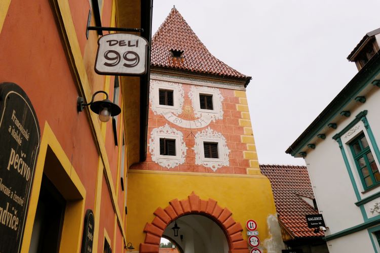 A handsome yellow and red building with pointy terracotta roof housing Deli 99  - where to east in Cesky Krumlov with kids