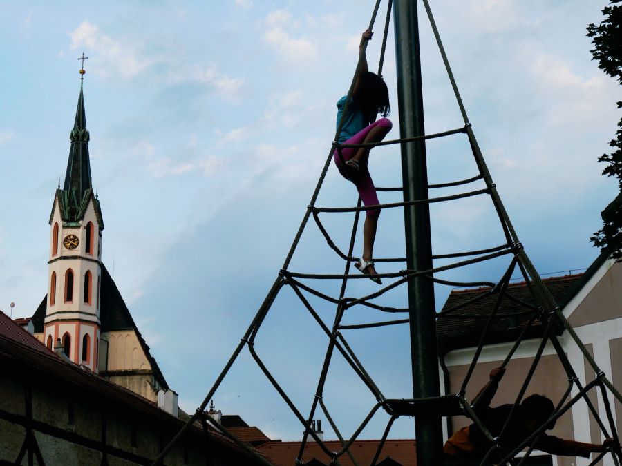 Small child climbing on a large rope structure in the playground in historic centre Cesky Krumlov - The Little Adventurer