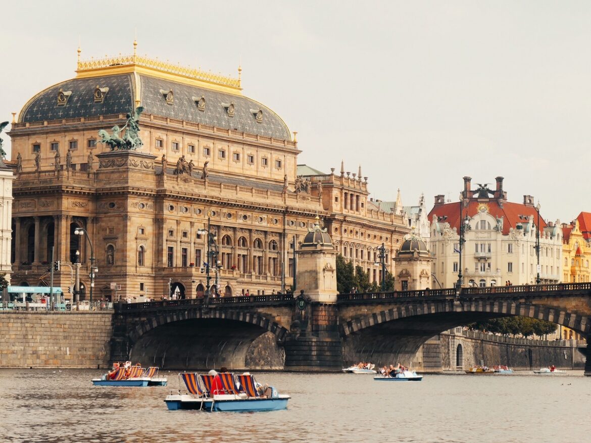 Families paddleboating down the Vltava river in front of the splendid National Theatre - one of the kid-friendly actvities while staying at one of the best hotels in Prague for families