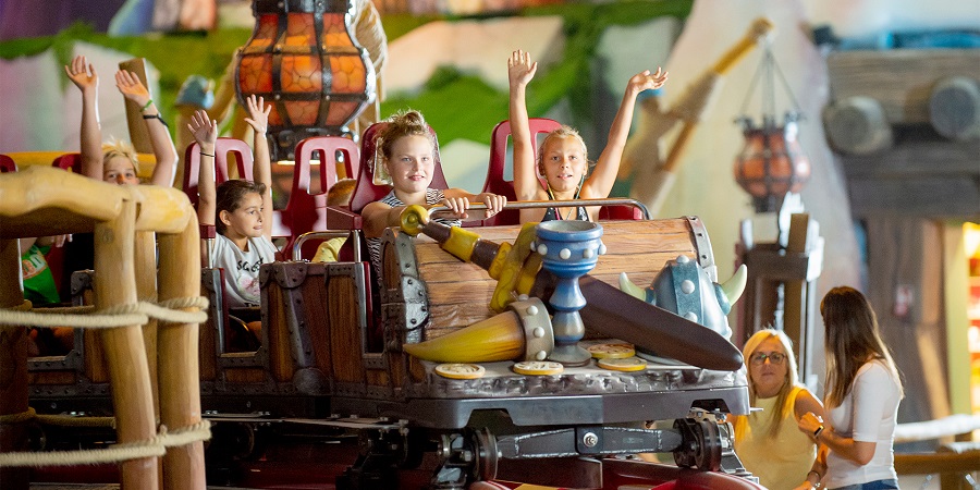 Kids riding a small rollercoaster at Mayaland amusement park close to Prague airport - fun indoor activities for kids in Prague 