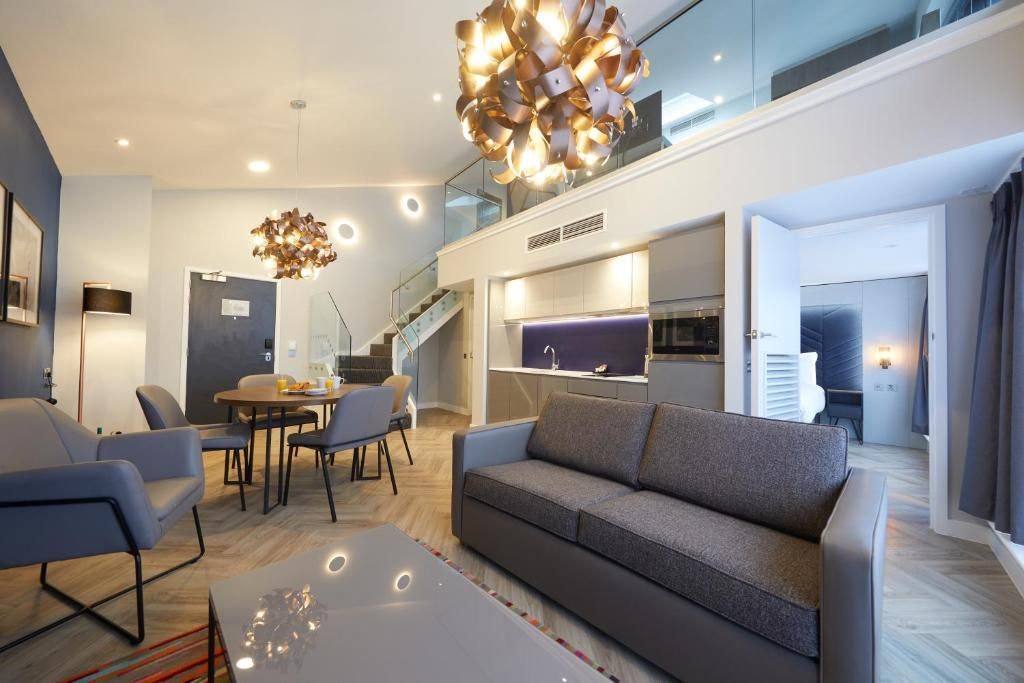 Family friendly apartment in Roomzzz York with living room, kitchenette and dining table, with stairs leading to a mezzaine level